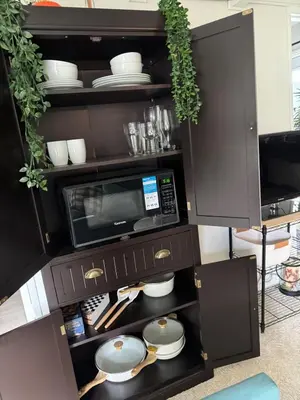 a cabinet with a microwave and dishes in it at My Cozy Place in Mission Viejo