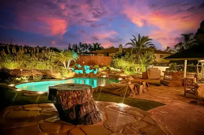 a pool with a tree stump in the middle of a yard at O-side Oasis in Oceanside