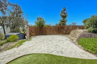 a backyard with a sand path and a wooden fence at O-side Oasis in Oceanside