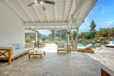 a patio with a couch and chairs and a pool at O-side Oasis in Oceanside