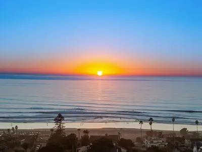 a sunset over the ocean with a beach at Golden Hour by Coastline Vacation Rentals in Encinitas