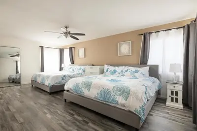a bedroom with two beds and a ceiling fan at Blue Tide by Coastline Vacation Rentals in San Diego