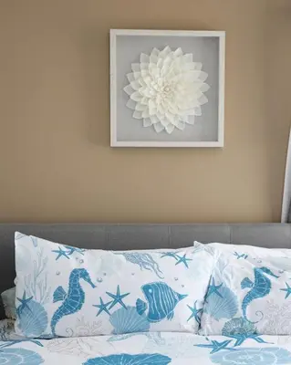 a bed with a pillow and a picture on the wall at Blue Tide by Coastline Vacation Rentals in San Diego