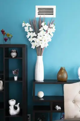 a vase filled with white flowers on a shelf at Blue Tide by Coastline Vacation Rentals in San Diego