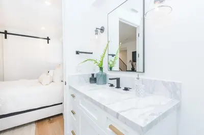 a white bathroom with a sink and a mirror at 6Br Tri-Level W Ac, Ocean Views, Rooftop Deck And Hot Tub By Beachview Rentals in Newport Beach