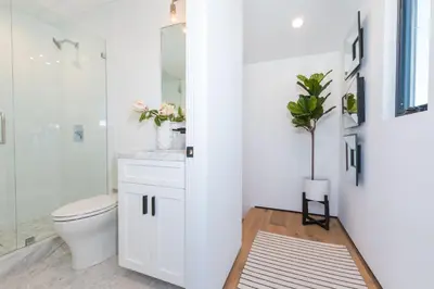 a white bathroom with a toilet and a shower at 6Br Tri-Level W Ac, Ocean Views, Rooftop Deck And Hot Tub By Beachview Rentals in Newport Beach