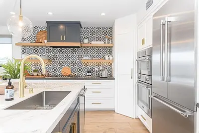 a kitchen with a stainless steel refrigerator and white cabinets at 6Br Tri-Level W Ac, Ocean Views, Rooftop Deck And Hot Tub By Beachview Rentals in Newport Beach