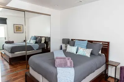 a bedroom with two beds and a mirror at Chic SD Basecamp - Walk to Downtown in San Diego