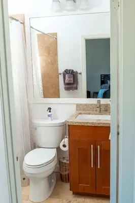 a bathroom with a toilet and a sink and a mirror at Chic SD Basecamp - Walk to Downtown in San Diego