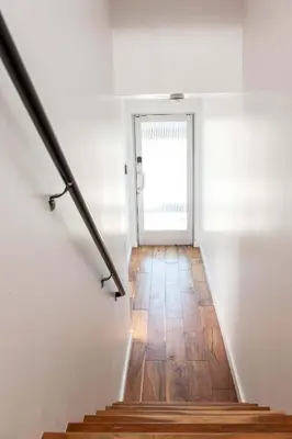 a hallway with a stairway leading to a door at Chic SD Basecamp - Walk to Downtown in San Diego