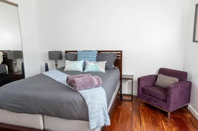 a bedroom with a bed and a purple chair at Chic Downtown SD Hub for Families & Friends in San Diego