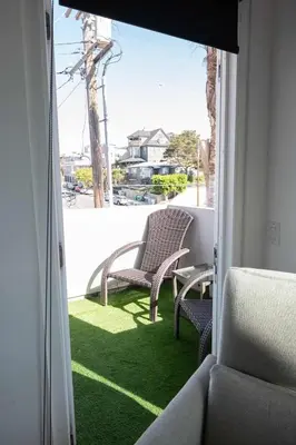 a balcony with two chairs sitting on the grass at Chic Downtown SD Hub for Families & Friends in San Diego