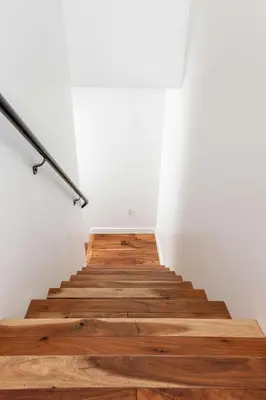 a staircase with wooden floor and white walls at Chic Downtown SD Hub for Families & Friends in San Diego