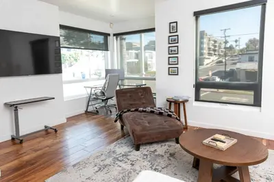a living room with a tv and a table at Chic Downtown SD Hub for Families & Friends in San Diego