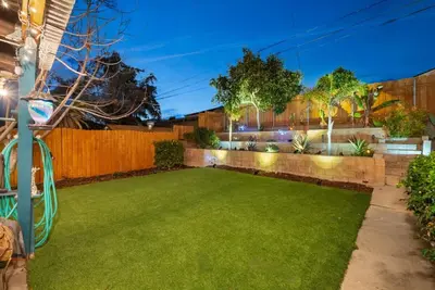 a yard with a fence and a green lawn at The Mosaic by Coastline Vacation Rentals in San Diego