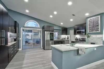 a large kitchen with blue walls and a counter top at Modern Design Temecula House-30 in Temecula