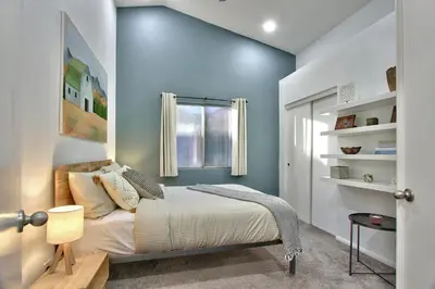 a bedroom with a bed with a blue wall at Modern Design Temecula House-30 in Temecula
