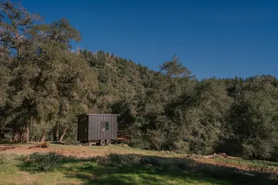 a small train car parked in front of a forest at Off-Grid Tiny Home Pacific Views & Serenity in Pauma Valley