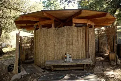 a wooden pergola with two bottles on top of it at Tiny Home Above the Clouds Pacific Views in Pauma Valley