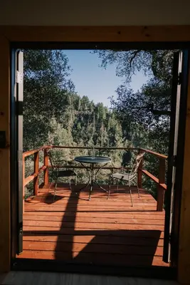a patio with a table and chairs on a deck at Tiny Home Above the Clouds Pacific Views in Pauma Valley
