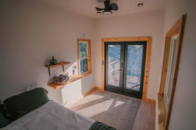 a bedroom with a bed and a sliding glass door at Tiny Home Above the Clouds Pacific Views in Pauma Valley