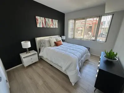 a bedroom with a large bed and a window at Stylish Gaslamp 1BR Den Patio Walk Everywhere in San Diego