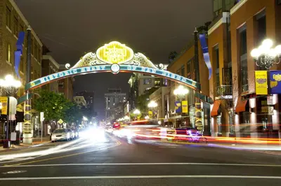 a city street with cars driving under an arch at night at Stylish Gaslamp 1BR Den Patio Walk Everywhere in San Diego