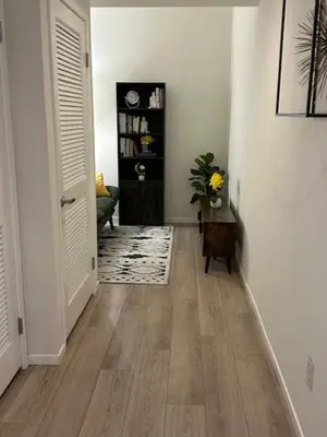 a hallway with white walls and wooden floors and a door at Stylish Gaslamp 1BR Den Patio Walk Everywhere in San Diego