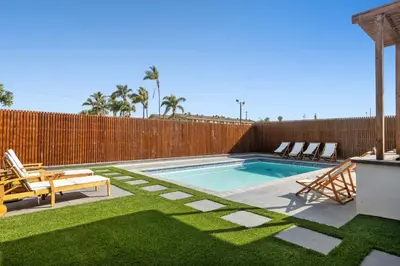 a swimming pool with chairs and a fence at Family Pool House Oasis in National City