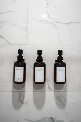 three bottles of soap sitting on top of a counter at Family Pool House Oasis in National City