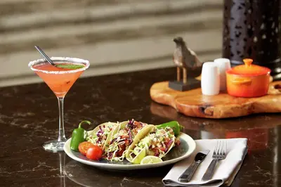 a table with a plate of food and a drink at Hilton Garden Inn San Diego Mission Valley/Stadium in San Diego