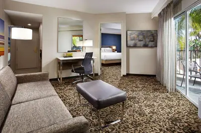 a hotel room with a couch and a desk and a bed at Hilton Garden Inn San Diego Mission Valley/Stadium in San Diego