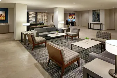 a hotel lobby with couches and tables and a piano at Hilton Garden Inn San Diego Mission Valley/Stadium in San Diego