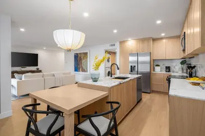 a kitchen and living room with a table and chairs at Marina Dream - Lagoon Views in Carlsbad