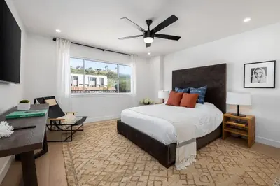 a bedroom with a bed and a desk and a window at Marina Dream - Lagoon Views in Carlsbad