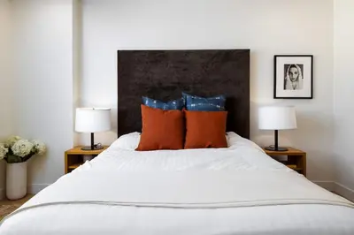 a bedroom with a bed with orange pillows and two lamps at Marina Dream - Lagoon Views in Carlsbad