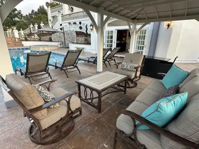 a patio with chairs and a couch and a table at San Diego French Garden Poolside Retreat - Wine Country & Safari Park in Escondido