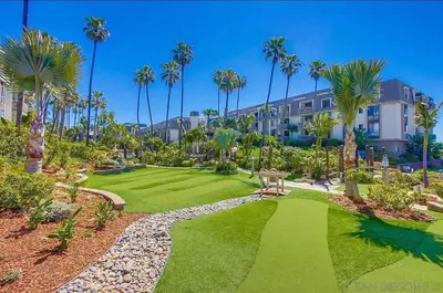 an image of a resort yard with palm trees at Panoramic Ocean View Beachfront Condo in Oceanside