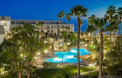 an aerial view of a resort with a pool and palm trees at Panoramic Ocean View Beachfront Condo in Oceanside