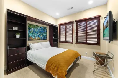 a bedroom with a king sized bed and a tv at Tuscan Sands by Coastline Vacation Rentals in San Diego