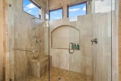 a bathroom with a shower with a glass door at Tuscan Sands by Coastline Vacation Rentals in San Diego