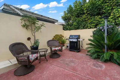 a patio with chairs and a grill and a table at Tuscan Sands by Coastline Vacation Rentals in San Diego