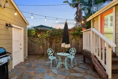 a patio with a table and two chairs and an umbrella at Lotus House by Coastline Vacation Rentals in San Diego