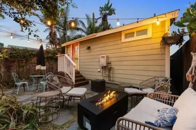 a patio with chairs and a fireplace and a house at Lotus House by Coastline Vacation Rentals in San Diego