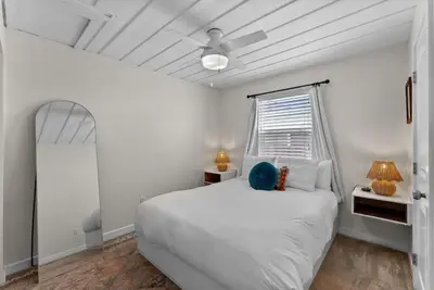 a white bedroom with a bed and a window at Lotus House by Coastline Vacation Rentals in San Diego