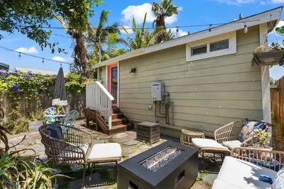 a patio with chairs and a grill in front of a house at Lotus House by Coastline Vacation Rentals in San Diego