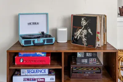 a table with a radio and a picture and books at Lotus House by Coastline Vacation Rentals in San Diego