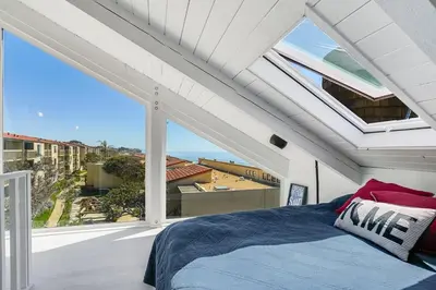 a bedroom with a bed and a large window at Luxury Beachfront Townhouse with Breathtaking Views in Solana Beach