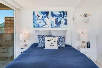 a bedroom with a blue bed with a face pillow at Luxury Beachfront Townhouse with Breathtaking Views in Solana Beach