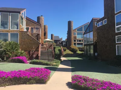 a walkway in front of a building with purple flowers at Luxury Beachfront Townhouse with Breathtaking Views in Solana Beach